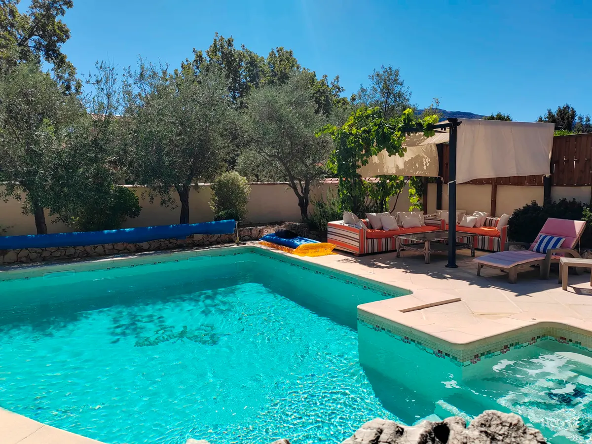 Piscine et salon lounge ombragé sous la pergola