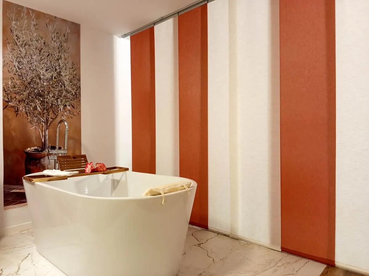 Baignoire îlot devant rideaux terracotta et fresque olivier